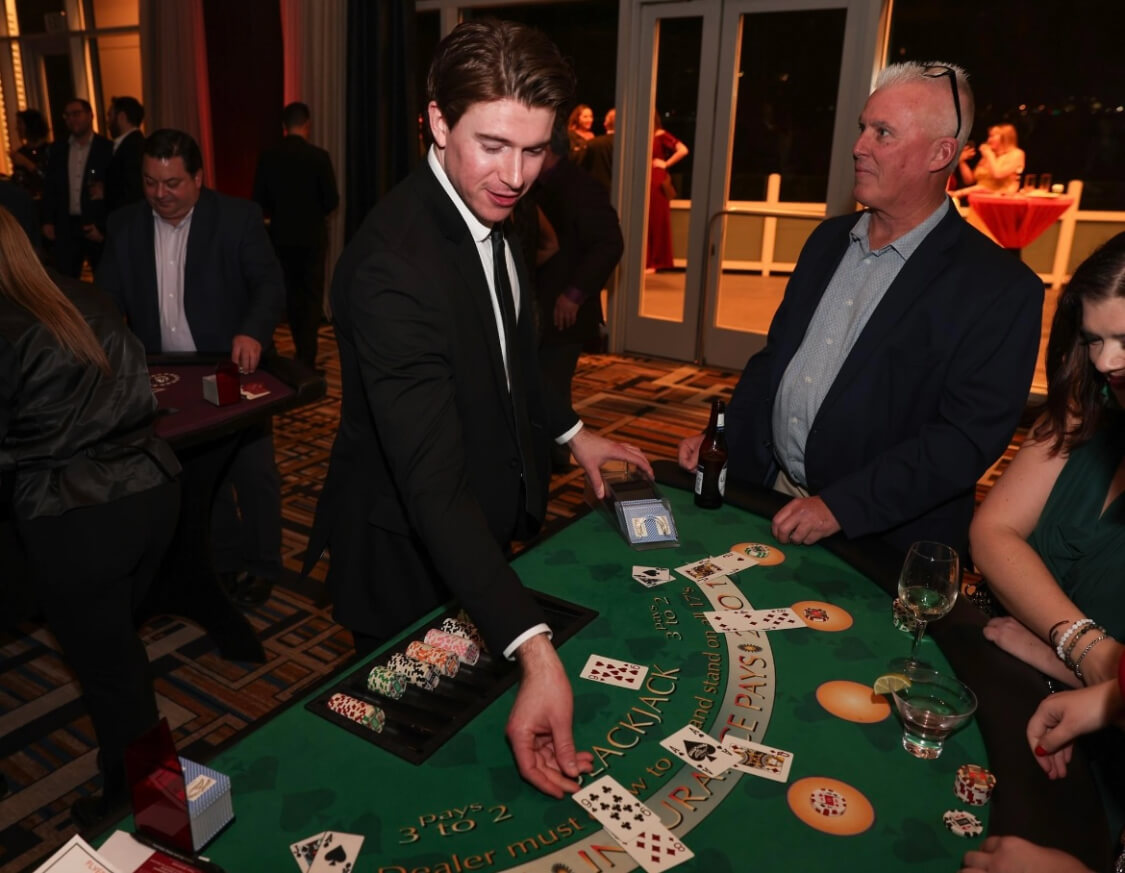 A person placing a card on a casino table